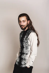 a man with long hair and a tie dye shirt