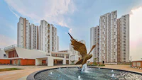 a fountain with an eagle statue in front of tall buildings