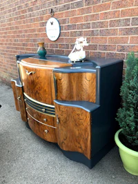 a sideboard with drawers and a plant in front of it