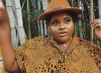 a woman wearing a leopard print shirt and a hat