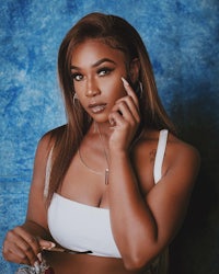 a woman in a white top and white bra posing for a photo
