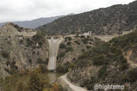 a dam with a waterfall in the middle of a mountain