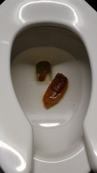 a toilet with a piece of food in it