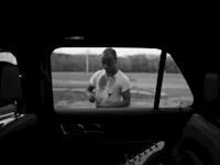 a black and white photo of a man in a car