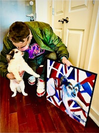 a man holding a painting of a dog