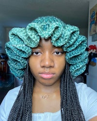 a woman wearing a crocheted ruffled hat