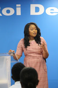a woman in a pink dress standing in front of a podium