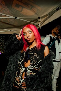 a woman with pink hair posing for a picture