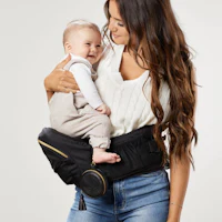 a woman holding a baby in a baby carrier