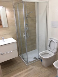 a bathroom with a toilet, sink and shower stall