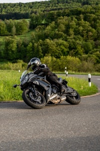 a person riding a black motorcycle on a curvy road