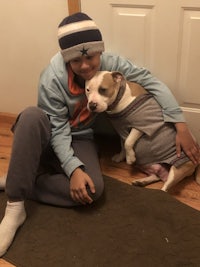 a young man sitting on the floor with a dog