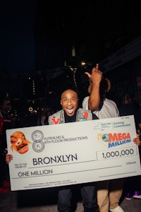 a man holding up a large check in front of a crowd