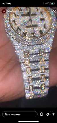 a person is holding a watch with diamonds on it