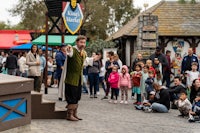 a group of people watching a magician perform in front of a crowd