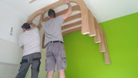 two men working on a wooden ceiling in a room