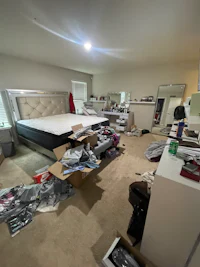 a messy bedroom with a bed and other furniture