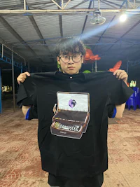 a young man holding up a t - shirt with a picture of a piano
