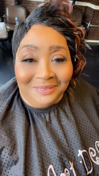 a woman in a hair salon smiling at the camera