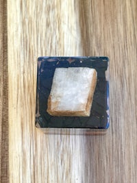 a square piece of quartz sitting on top of a wooden table