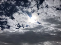 the sun shines through a cloudy sky