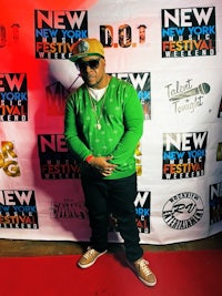 a man standing on a red carpet at a new york music festival