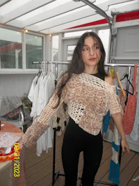 a woman standing in front of a rack of clothes