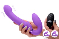 a hand holding a purple vibrating toy with a remote control