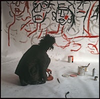 a man sitting on the floor with paint on his face