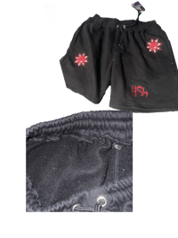 a pair of black shorts with a red star on them