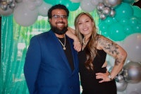 a man and woman posing for a photo in front of balloons