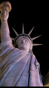 the statue of liberty is lit up at night