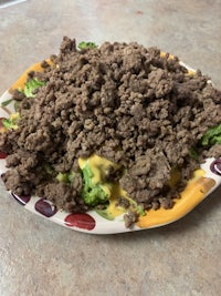 a plate with beef, broccoli and cheese on it