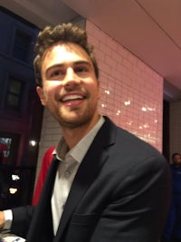 a man in a suit is smiling at a table