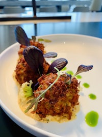 a white plate with a crab cake on it