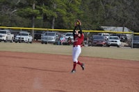 a softball player catching a ball on a field