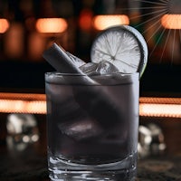 a cocktail with ice and a slice of lime