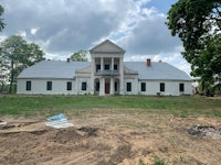 a white house is being built in the middle of a field