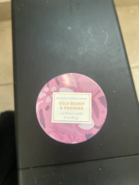 a sticker with a pink flower on it sits on top of a black box