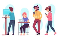 a group of people sitting at a desk and using computers