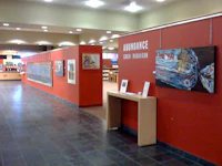 a red wall in a library with paintings on it