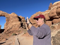 a man taking a picture of a rock formation