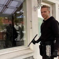 a man holding a gun in front of a house