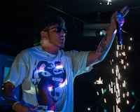 a man is holding a microphone while holding sparklers