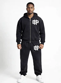 a man wearing a black hoodie and jogging pants