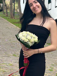 a woman in a black dress holding a bouquet of flowers