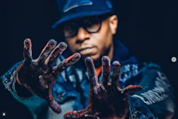 a man in a hat with blood on his hands