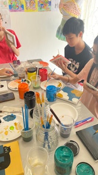 a group of children are painting at a table