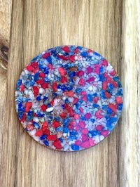 a red, white and blue coaster on a wooden table