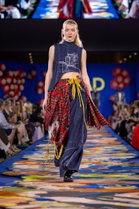 a model walks down the runway wearing a plaid skirt and top